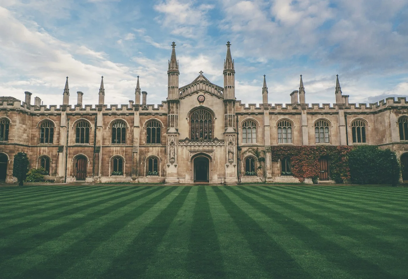 A historic university building and a green courtyard