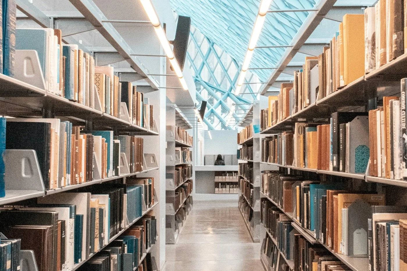 A bright aisle between library bookshelves