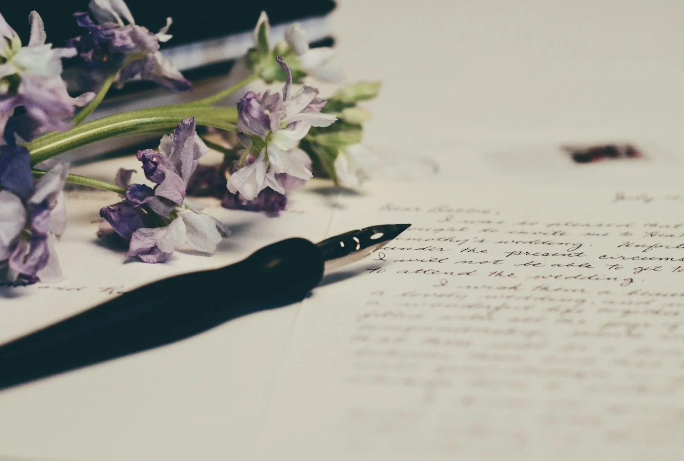 Handwritten text and a fountain pen on a desk